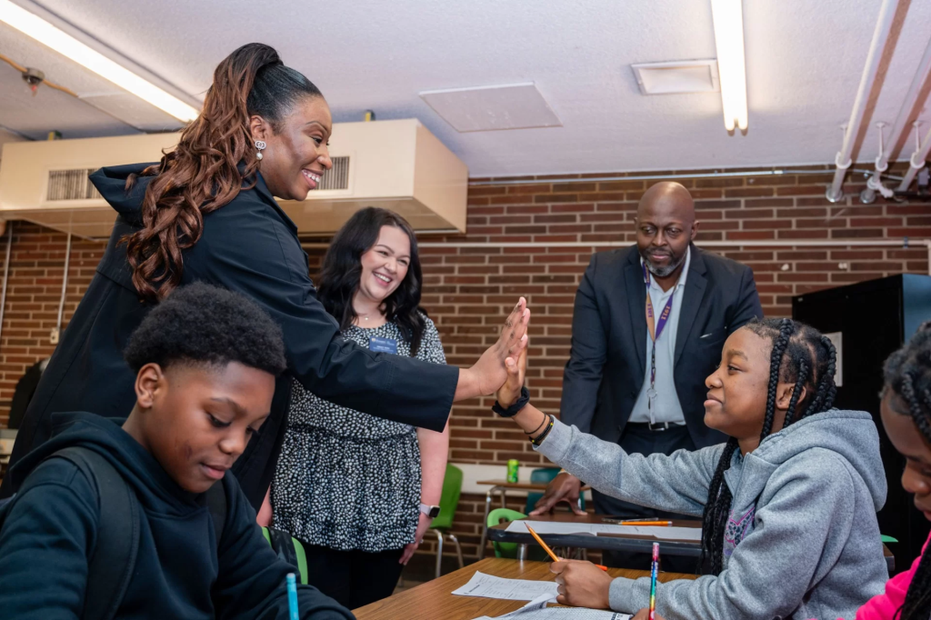 UNCG grad students Grace Finn and Chidinma Ezugwu tutor at Jackson Middle School, with Guilford County Schools tutoring coordinator John Brown observing.